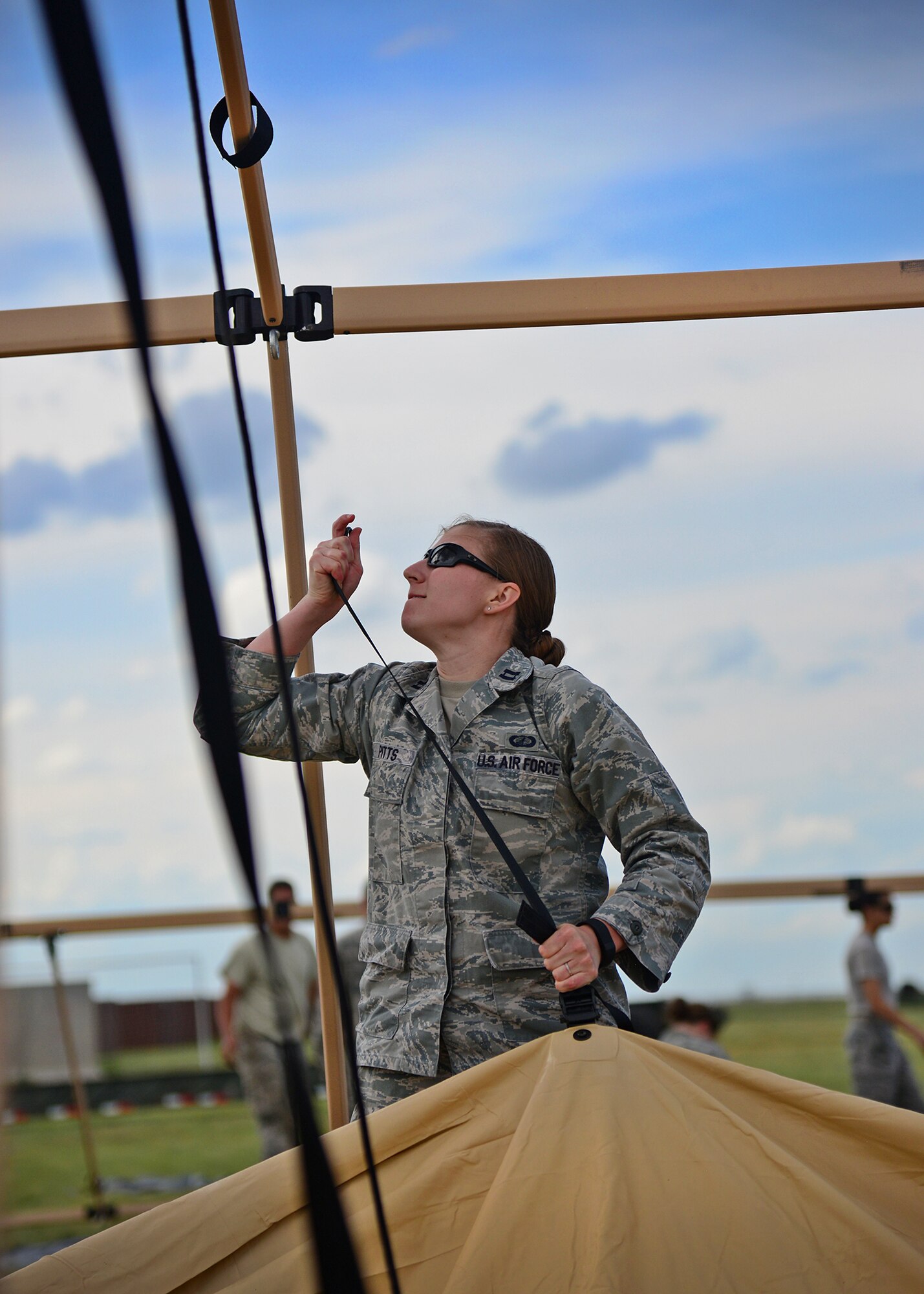 U.S. Air Force Capt. Jessica Pitts, 27th Special Operations Comptroller Squadron budget chief, hoists a canvas tent to attach to its frame during an exercise June 8, 2015 at Melrose Air Force Range, New Mexico. During the exercise, finance and contracting Air Commandos received financial training and practiced managing contracts and contract personnel in a contingency environment. (U.S. Air Force photo/Senior Airman Chip Slack)