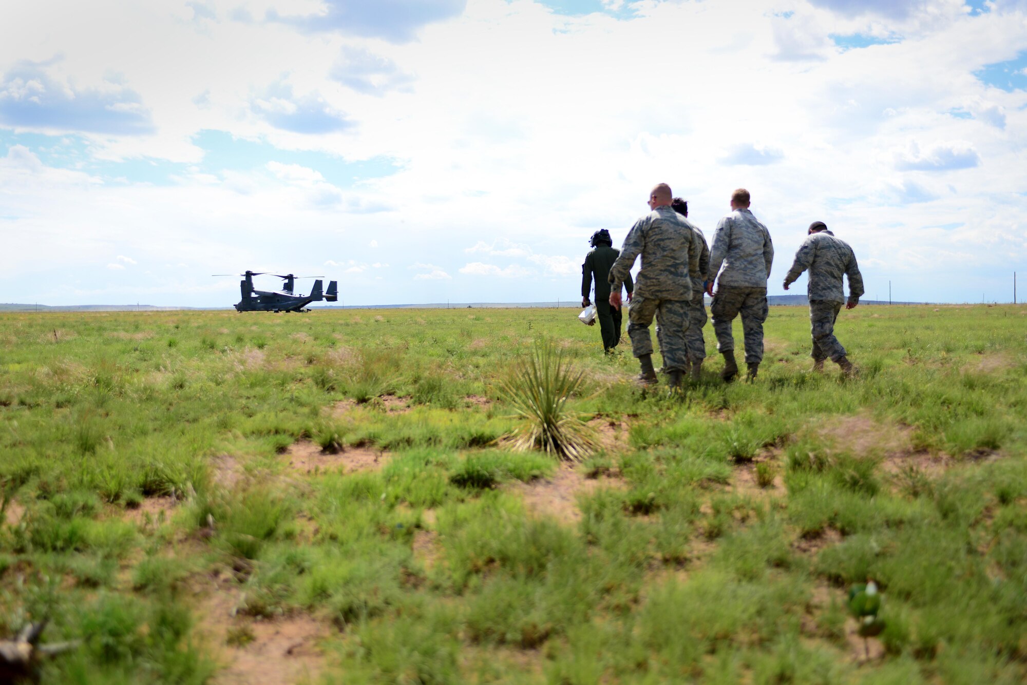 Airmen walk toward a CV-22 Osprey during an exercise June 9, 2015 at Melrose Air Force Range, N.M. During the exercise, finance and contracting Air Commandos received financial training and practiced managing contracts and contract personnel in a contingency environment. (U.S. Air Force photo/Senior Airman Eboni Reece)