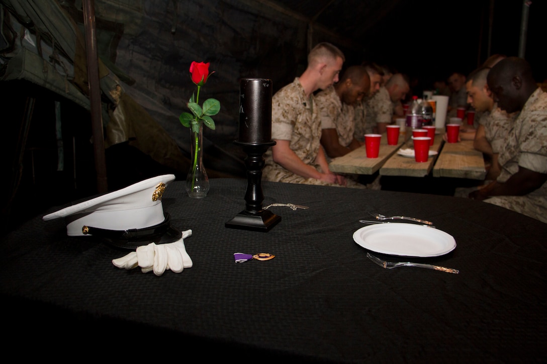 Marines bow their heads for a moment of silence dedicated to their fallen comrades during Recruiting Station Milwaukee’s mess night, June 11, 2015.  “The table is draped in black, symbolizing the color of mourning; the ultimate sacrifice, a table set in honor of our fallen comrades.”