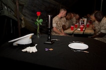 Marines bow their heads for a moment of silence dedicated to their fallen comrades during Recruiting Station Milwaukee’s mess night, June 11, 2015.  “The table is draped in black, symbolizing the color of mourning; the ultimate sacrifice, a table set in honor of our fallen comrades.”