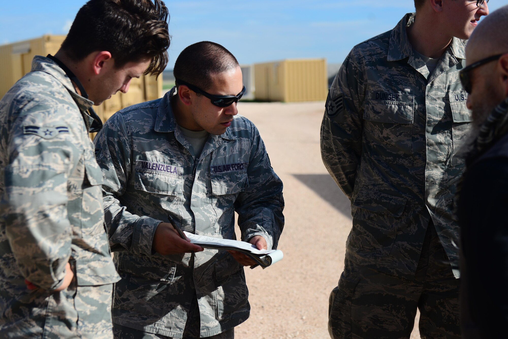 U.S. Air Force Senior Airman David Valenzuela, 27th Special Operations Contracting Squadron contracting specialist, negotiates a contract with opposing forces players acting as local entrepreneurs as part of an exercise June 9, 2015 at Melrose Air Force Range, N.M.  During the exercise, finance and contracting Air Commandos received financial training and practiced managing contracts and contract personnel in a contingency environment. (U.S. Air Force photo/Airman 1st Class Shelby Kay-Fantozzi)