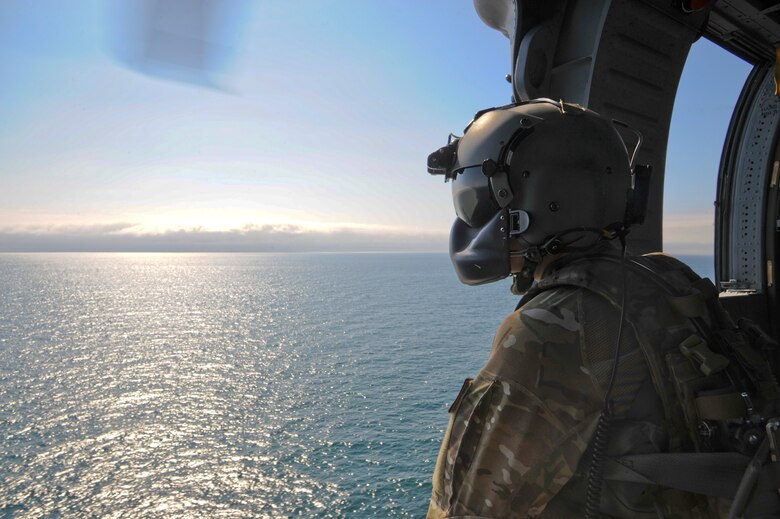 U.S. Air Force Senior Airmen Talon Leinbaugh, 66th Rescue Squadron aerial gunner, conducts aerial surveillance in an HH-60G Pave Hawk over the Pacific Ocean during Angel Thunder 2015, June 11, 2015. Angel Thunder is hosted by the 355th Fighter Wing at Davis-Monthan Air Force Base, Ariz., but many flying operations will extend throughout Arizona, New Mexico and California. Leinbaugh is stationed at Nellis Air Force Base, Nev. (U.S. Air Force photo by Senior Airman Betty R. Chevalier/Released)