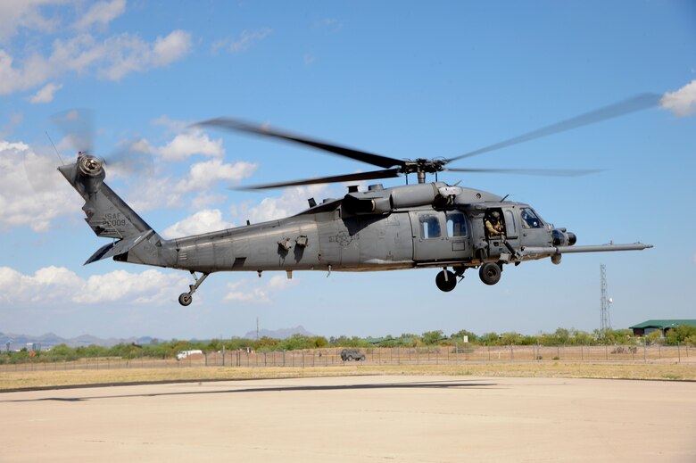 A U.S. Air Force HH-60G Pave Hawk from the 66th Rescue Squadron hovers over the flightline as pre-flight checks are conducted before departing Davis-Monthan Air Force Base, Ariz., for a mass casualty exercise during Angel Thunder 2015, June 11, 2015. Angel Thunder is an Air Combat Command-sponsored personnel recovery exercise for combat air force, joint, allied and interagency participants. The 66th RQS is stationed at Nellis AFB, Nev. (U.S. Air Force photo by Senior Airman Betty R. Chevalier/Released)