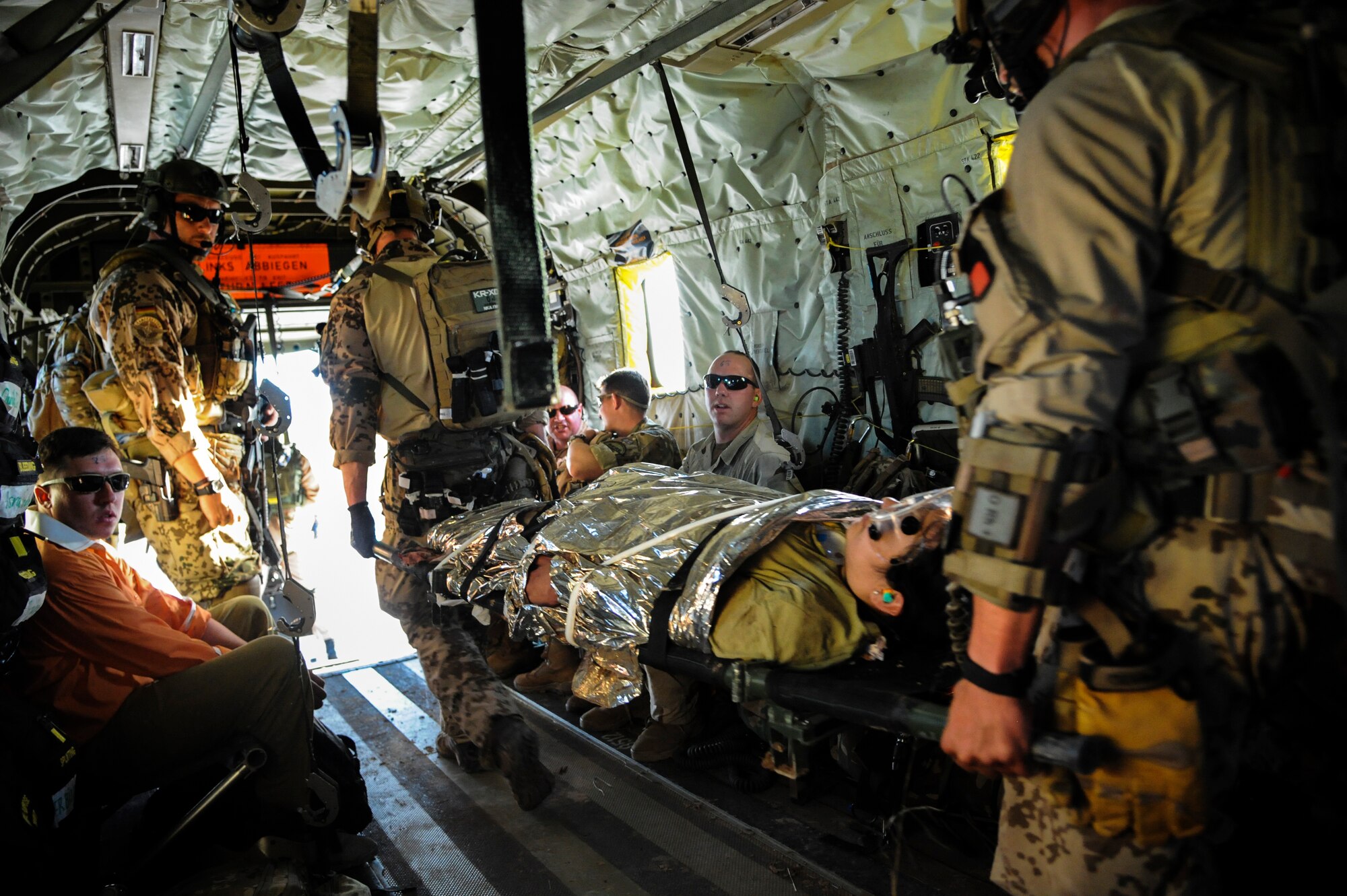 German and U.S. Air Force pararescuemen move a simulated patient from a CH-53GS helicopter to a C-130 Hercules for transportation during an Angel Thunder 2015 mass casualty exercise at Bisbee-Douglas International Airport, Ariz., June 9, 2015. U.S. military forces and partner nations worked together during the exercise to rescue and extract patients from Playas Research and Training Center, N.M. (U.S. Air Force photo by Senior Airman Betty R. Chevalier/Released)