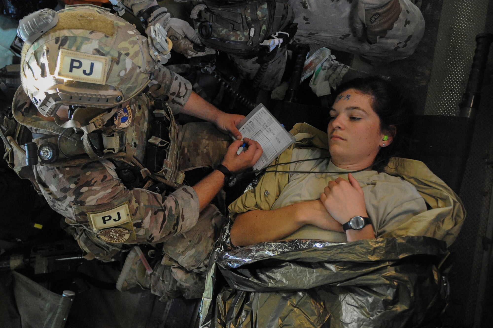 A U.S. Air Force 48th Rescue Squadron pararescueman writes down completed care on a field medical card for a simulated patient during an Angel Thunder 2015 mass casualty exercise in route to Bisbee-Douglas International Airport, Ariz., June 9, 2015. Mock victims in the exercise were brought to a casualty collection point where they were triaged and transferred to a U.S. Air Force HH-60 Pave Hawk, U.S. Navy MH-60 Sea Hawk or a German CH-53GS for a medical evacuation. (U.S. Air Force photo by Senior Airman Betty R. Chevalier/Released)