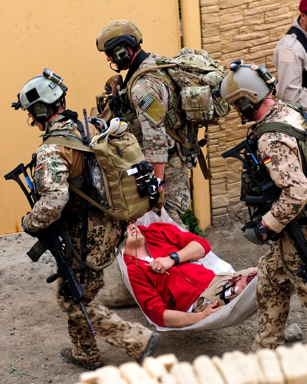 U.S. and German service members carry a simulated casualty during a mass casualty exercise apart of Angel Thunder 2015 at a training site outside of Marine Corps Base Camp Pendleton, Calif., June 11, 2015. The objective of the exercise was to clear the area of opposing forces and stablilze and safely extricate simulated casualties. (U.S. Air Force photo by Airman 1st Class Chris Drzazgowski/Released)