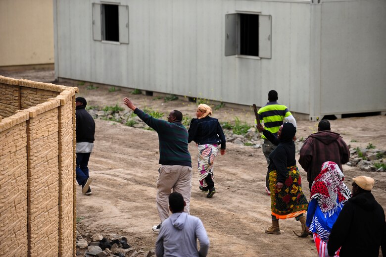 Simulated protesters cause a disturbance outside the walls of a simulated American embassy during a mass casualty exercise apart of Angel Thunder 2015 at a training site outside of Marine Corps Base Camp Pendleton, Calif., June 11, 2015. The objective of the exercise was to clear the area of opposing forces and stablilze and safely extricate simulated casualties. (U.S. Air Force photo by Airman 1st Class Chris Drzazgowski/Released) 