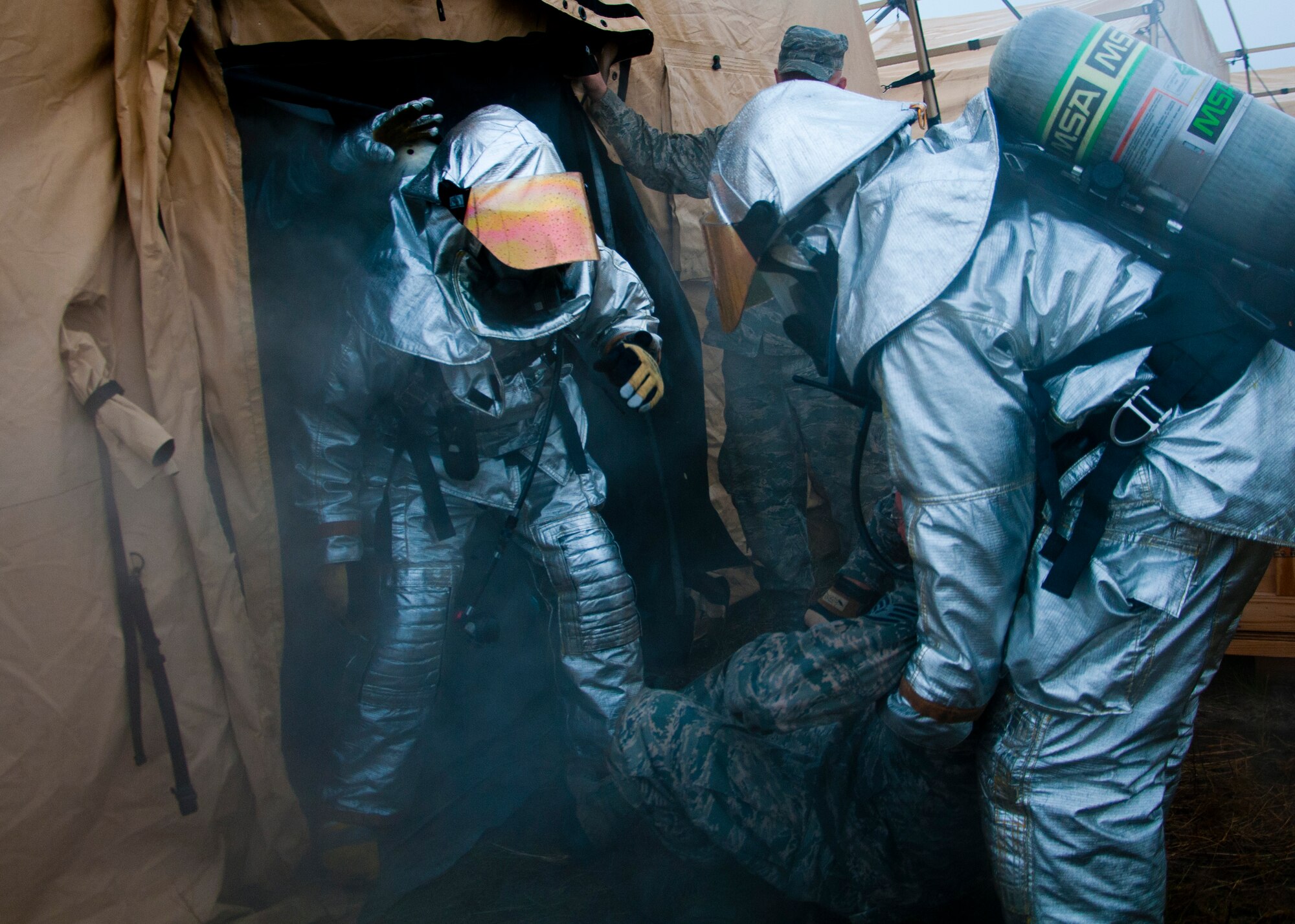Members of the 446th Civil Engineer Squadron Fire Protection Flight train to rescue a victim from a tent  filled with smoke at Fort McCoy WI. during Patriot Warrior, June 11th, 2015. Patriot Warrior is an Air Force Reserve Command exercise performed in a joint environment with U.S. Army and Navy Reserves, active duty and Air National Guard partners designed to evaluate the capability to deploy, establish and operate in support of joint operations. Nearly 6,000 U.S. Army Reserve, Navy Reserve and AFRC personnel took part in the exercise. The 446th Fire Protection Flight trained daily to keep their skills sharp in case of real world incidents during the exercise. (U.S. Air Force photo by Senior Airman Daniel Liddicoet/Released)