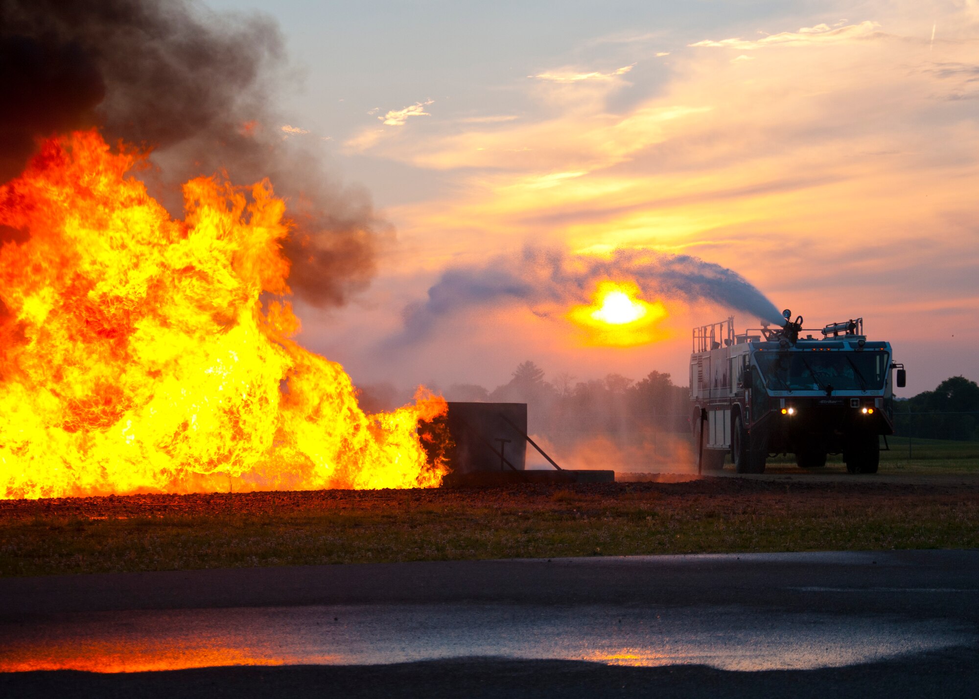 Members of the 446th Civil Engineer Squadron Fire Protection Flight train to put out a JP8 jet fuel fire at Fort McCoy WI. during Patriot Warrior, June 10th, 2015. Patriot Warrior is an Air Force Reserve Command exercise performed in a joint environment with U.S. Army and Navy Reserves, active duty and Air National Guard partners designed to evaluate the capability to deploy, establish and operate in support of joint operations. Nearly 6,000 U.S. Army Reserve, Navy Reserve and AFRC personnel took part in the exercise. The 446th Fire Protection Flight had a unique opportunity to train with JP8 jet fuel during the exercise, which simulates the conditions of real fires they might encounter much more closely than propane. (U.S. Air Force photo by Senior Airman Daniel Liddicoet/Released)