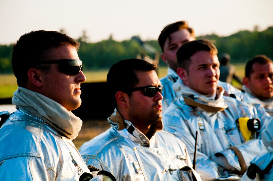 Members of the 446th Civil Engineer Squadron Fire Protection Flight meet before training to put out a JP8 jet fuel fire at Fort McCoy WI. during Patriot Warrior, June 10th, 2015. Patriot Warrior is an Air Force Reserve Command exercise performed in a joint environment with U.S. Army and Navy Reserves, active duty and Air National Guard partners designed to evaluate the capability to deploy, establish and operate in support of joint operations. Nearly 6,000 U.S. Army Reserve, Navy Reserve and AFRC personnel took part in the exercise. The 446th Fire Protection Flight team had a unique opportunity to train with JP8 jet fuel during the exercise, which simulates the conditions of real fires they might encounter much more closely than propane. (U.S. Air Force photo by Senior Airman Daniel Liddicoet/Released)