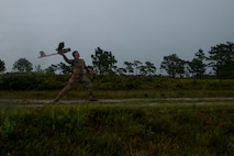 U.S. Air Force Master Sgt. Cory Hebb, 820th Combat Operations Squadron superintendent, throws an RQ-11B Raven for flight during Exercise DRAGON STRIKE June 10, 2015, at Avon Park Air Force Range, Fla. Hebb utilized the Raven to survey the area before an M142 High Mobility Artillery Rocket System launch. (U.S. Air Force photo by Airman 1st Class Dillian Bamman/Released)