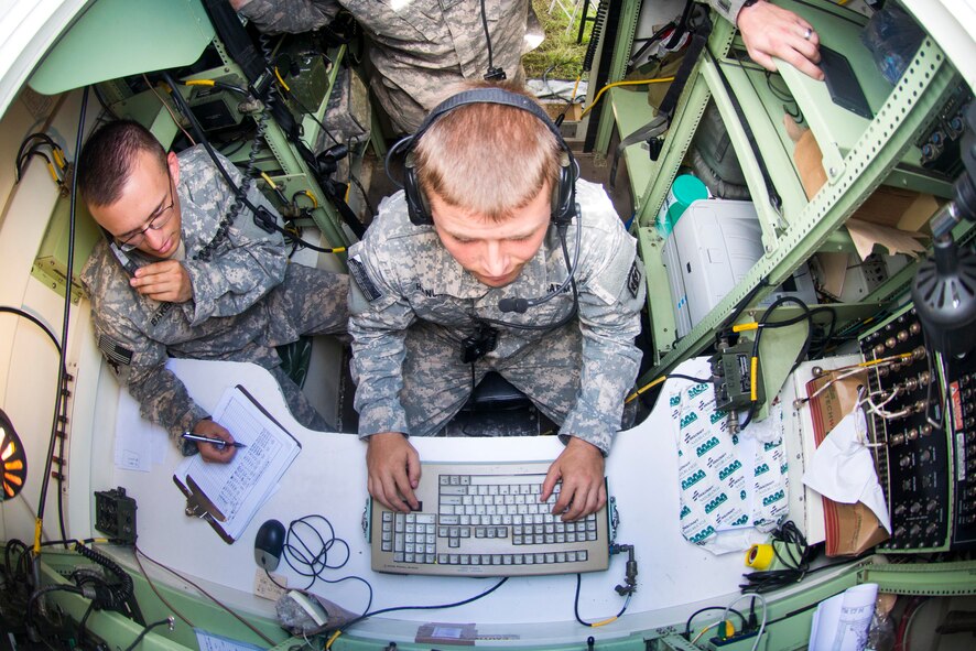 U.S. Army Spc. Evan Hanson, center, 3-27th Field Artillery Regiment 2nd Fires Platoon box operator, and Spc. Chris Baker, 3-27th FAR 2nd Fires Platoon driver, run through a simulated M142 High Mobility Artillery Rocket System (HIMARS) launch during Exercise DRAGON STRIKE June 10, 2015, at Avon Park Air Force Range, Fla. The 3-27th FAR performed two real-world HIMARS launches during the 8-day exercise. (U.S. Air Force photo by Airman 1st Class Dillian Bamman/Released)