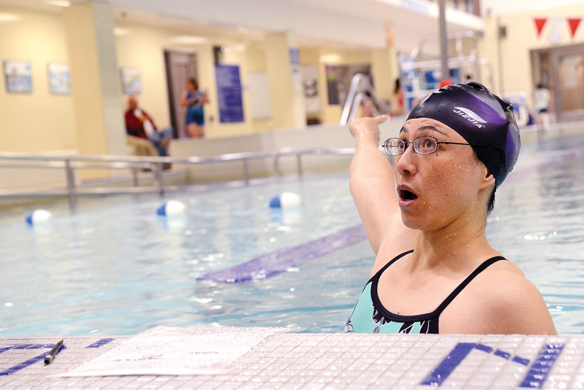 Mae-Lin Ynacay, lifeguard and water safety instructor with the Buckner Physical Fitness Center, informs the lifeguard on duty where the next lesson is being held June 2. The center offers swimming lessons for all ages starting at six months with a parent/child class, a ‘learn to swim’ class for ages 6 and older and adult swimming classes to refine the skill. (U.S. Air Force photo/Airman Christopher R. Morales)