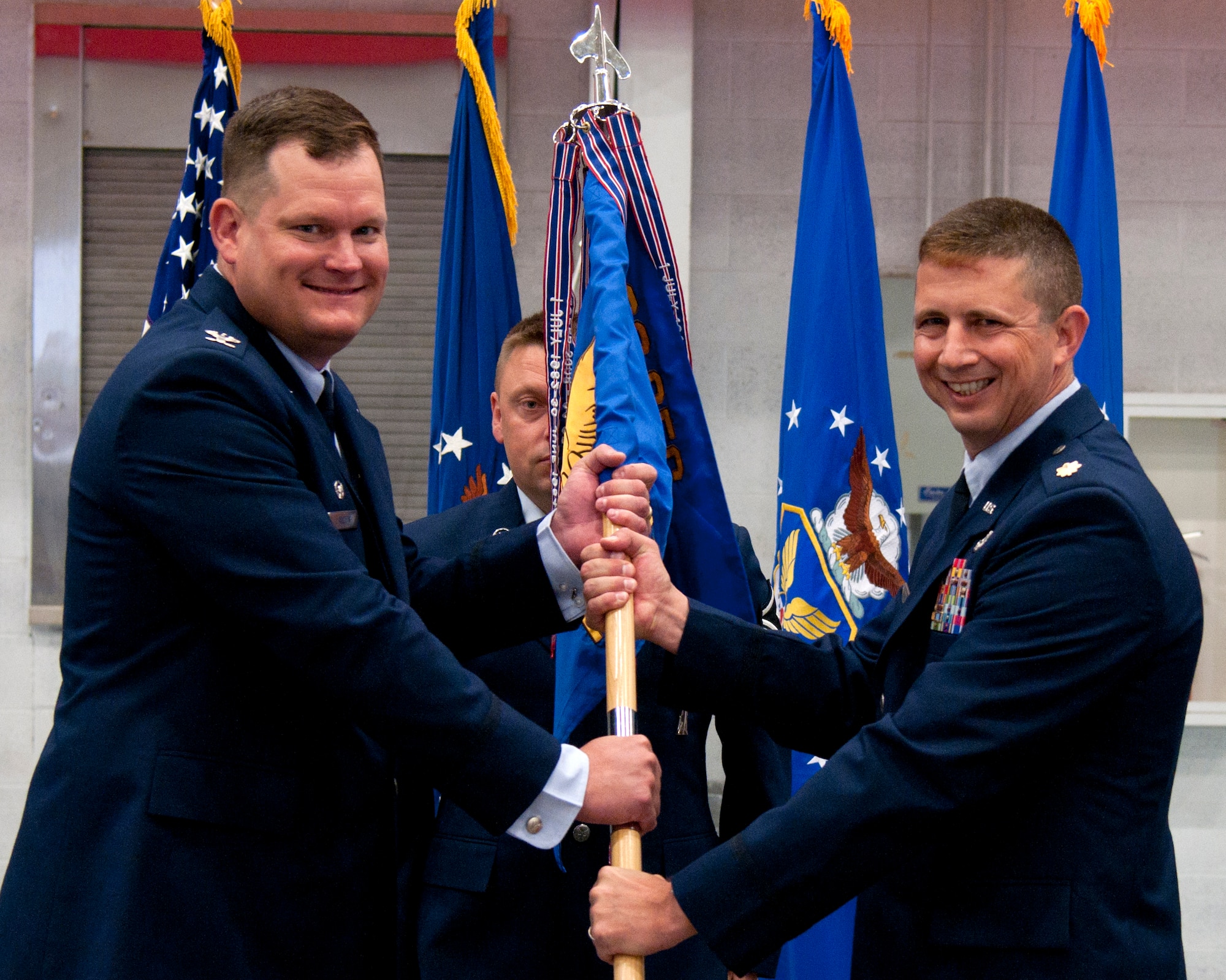 Col. Craig Allton, 90th Security Forces Group commander, passes the guidon to Maj. James Hughes, 90th Missile Security Forces Squadron commander, during the 90th MSFS change of command ceremony June 15, 2015, at F.E. Warren Air Force Base, Wyo. The ceremony signified the transition of command from Lt. Col. Peter Lex to Hughes. (U.S. Air Force photo by Airman 1st Class Malcolm Mayfield)