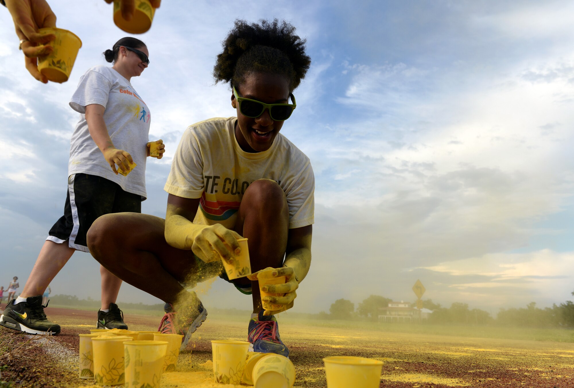 Staff Sgt. Ashley Nelson, 81st Communications Squadron client systems supervisor, prepares powder at a color station to coat runners with during Wingman Week’s “Resilient Color Me 5K”, June 8, 2015, Keesler Air Force Base, Miss. More than 170 Keesler personnel and family members participated in the run/walk, which featured a color station for each domain of Comprehensive Airmen Fitness – social, spiritual, mental and physical. (U.S. Air Force photo by Airman 1st Class Duncan McElroy)
