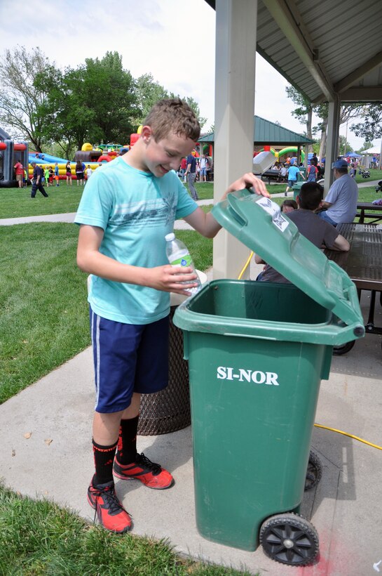 Kenneth Browder, son of Staff Sgt. Skyler Deveraux, 1st Airborne Command and Control Squadron, recycles a plastic water bottle June 5 during the Offutt Advisory Council Annual Appreciation Day Picnic at the Offutt Base Lake.  Recycling containers were a new addition to the picnic which has been held yearly for more than two decades. (U.S. Air Force photo by Staff Sgt. Rachelle Blake)