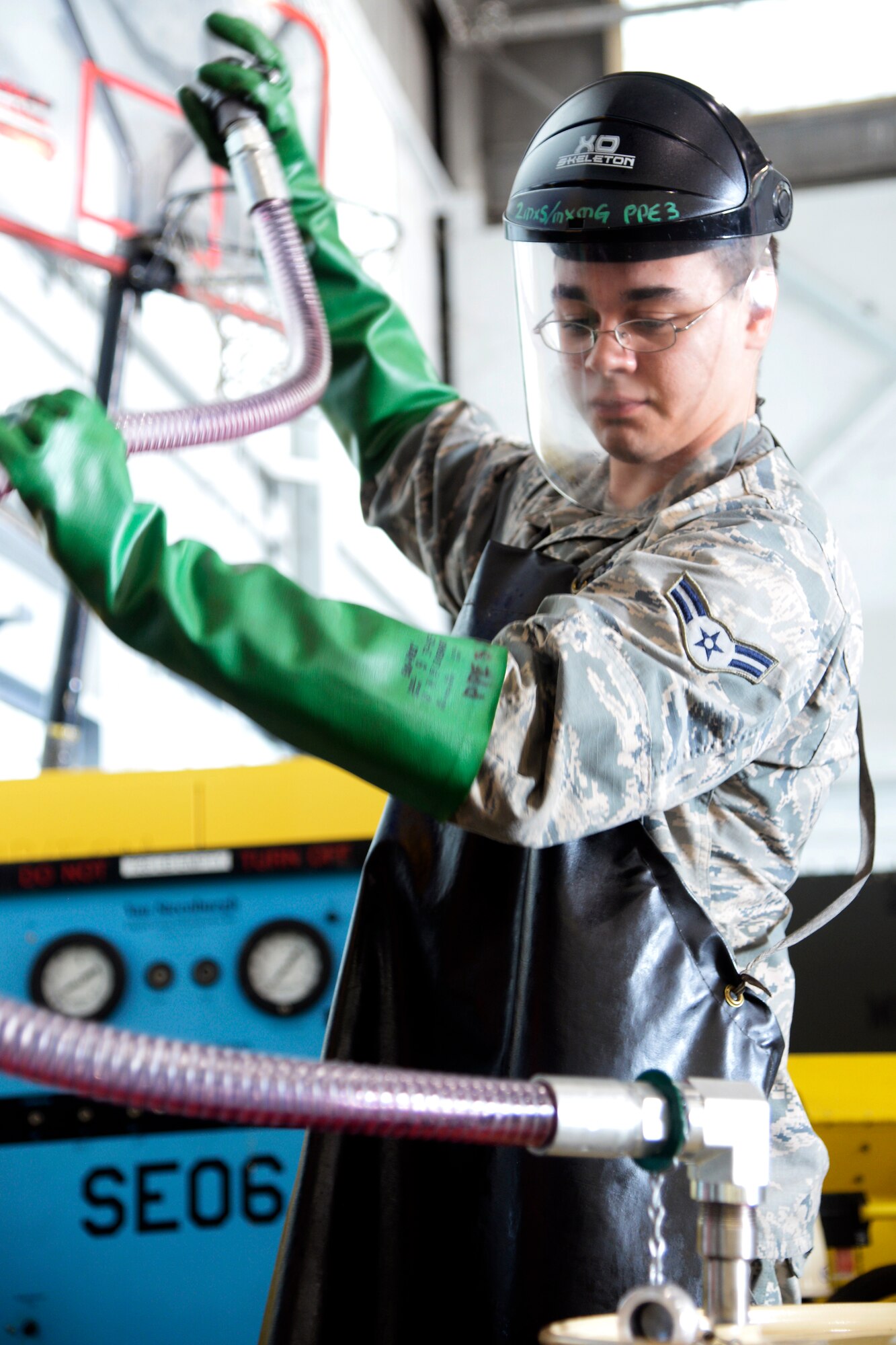 Airman 1st Class Ryan Thomas, 2nd Maintenance Squadron aerospace ground equipment journeyman, drains a hose into a barrel at Barksdale Air Force Base, La., June 12, 2015. Airmen in the AGE flight implemented an oil safe lubrication work center system to service equipment which reduced the total number of man-hours from 40 minutes to 10 minutes. (U.S. Air Force photo/Tech. Sgt. Marie Brown)