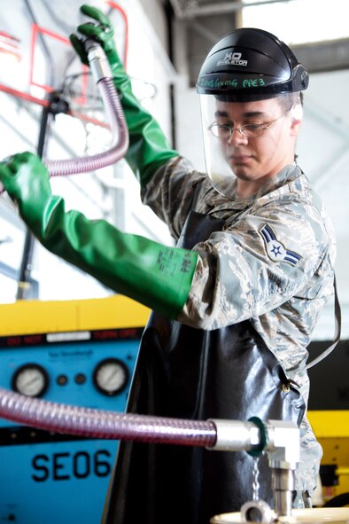 Airman 1st Class Ryan Thomas, 2nd Maintenance Squadron aerospace ground equipment journeyman, drains a hose into a barrel at Barksdale Air Force Base, La., June 12, 2015. Airmen in the AGE flight implemented an oil safe lubrication work center system to service equipment which reduced the total number of man-hours from 40 minutes to 10 minutes. (U.S. Air Force photo/Tech. Sgt. Marie Brown)