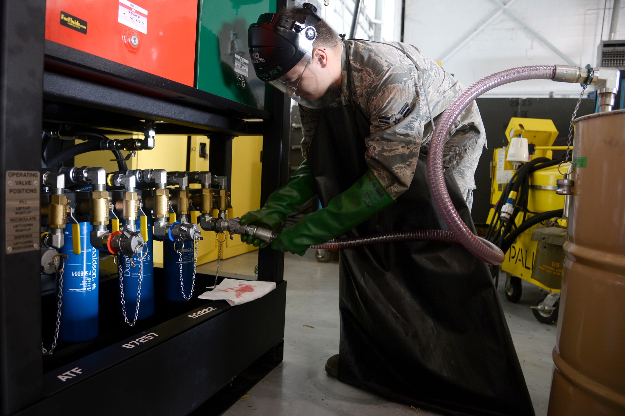 Airman 1st Class Ryan Thomas, 2nd Maintenance Squadron aerospace ground equipment journeyman, connects a hose to the new oil safe lubrication work center system at Barksdale Air Force Base, La., June 12, 2015. The new system houses eight 65-gallon tanks filled with four different types of engine oils and four different types of hydraulic fluid. (U.S. Air Force photo/Tech. Sgt. Marie Brown)