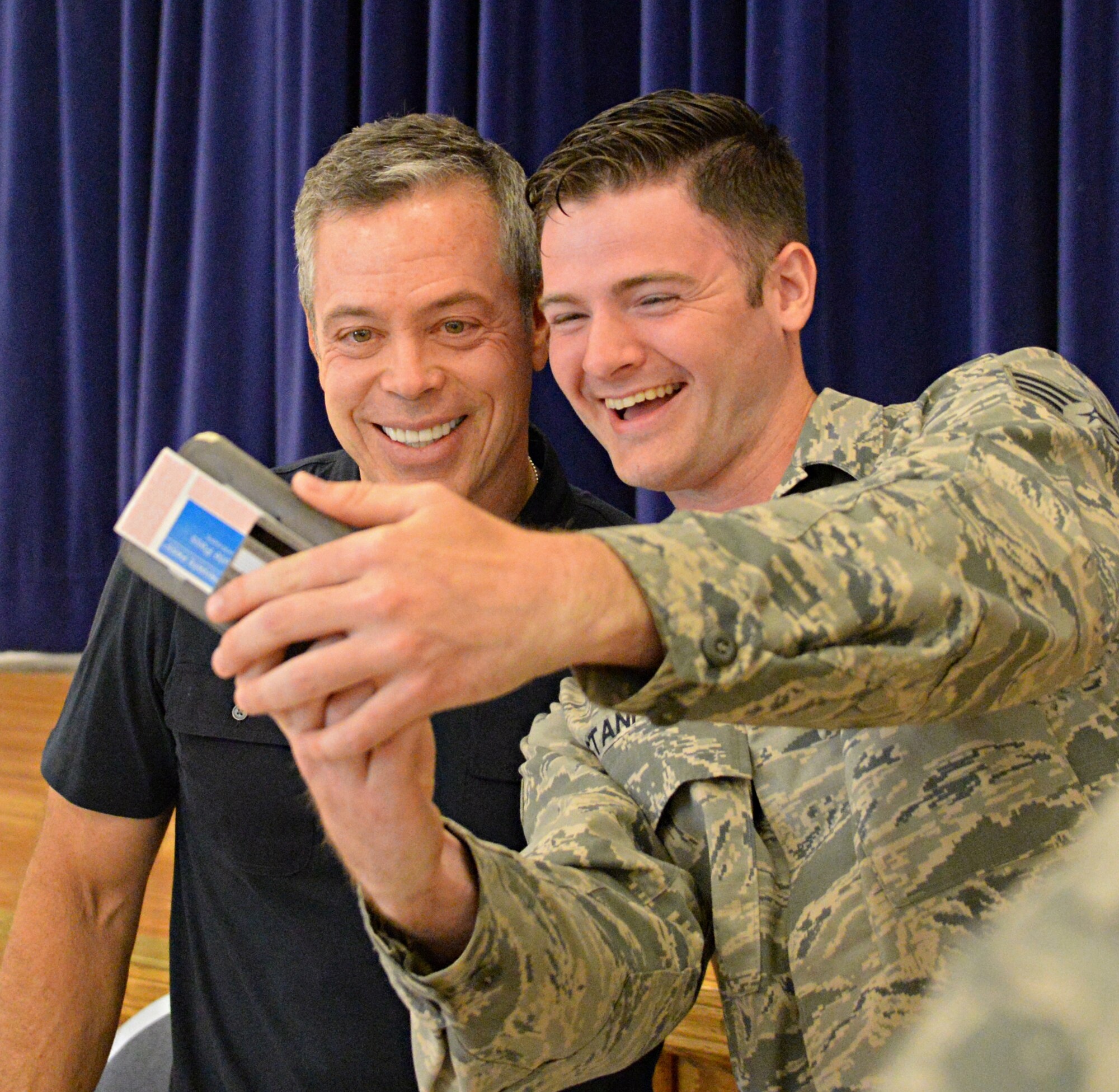Comedian Bernie McGrenahan takes a photo with a Beale Airman after his performance, “Comedy with a Message,” June 12, 2015, at Beale Air Force Base, California. McGrenahan began his comedy tour in 1995 to promote resiliency, safety, bystander intervention and respect. He also shares his experiences overcoming addiction. (U.S. Air Force photo by Airman 1st Class Ramon A. Adelan/Released)