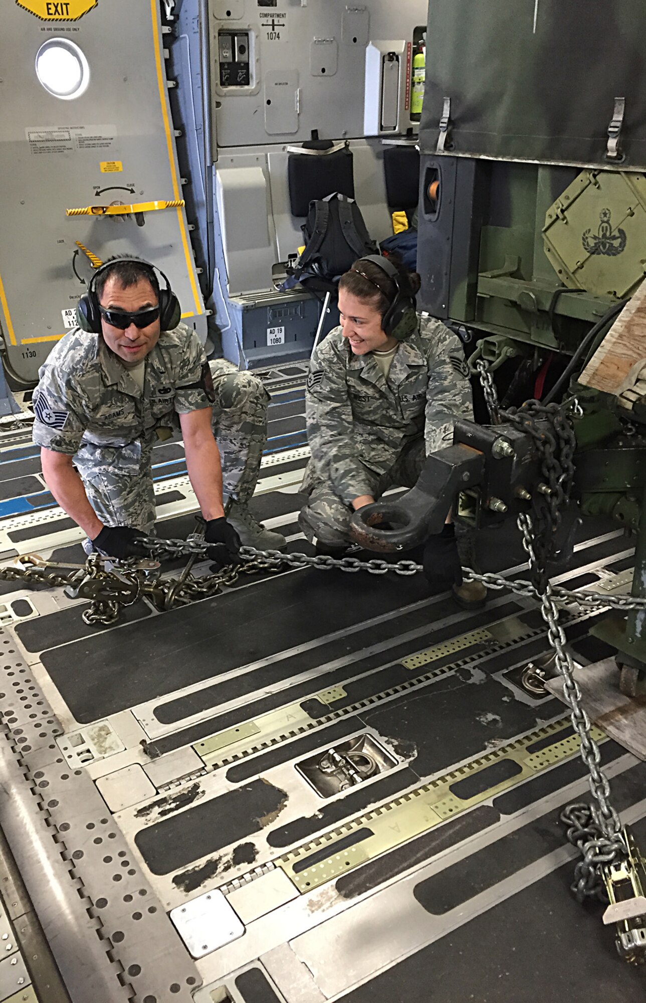 From left, Tech. Sgt. Robert Adams and Staff Sgt. Kelly West, both from the 86th Aerial Port Squadron, practice chaining down equipment on a C-17 Globemaster III June 11 at McChord Field. (Air Force Reserve photo by Master Sgt. Greg Tanner)