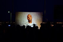 Chief Master Sgt. Adam McComb addresses his son, Garrett, via a prerecorded video at his high school graduation at Del Rio High School, Texas, June 5, 2015. Chief McComb recorded the video when he found out he’d be deployed on the day of his son’s graduation. (U.S. Air Force photo by Airman 1st Class Ariel D. Partlow)