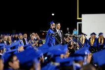 Garrett McComb, son of Chief Master Sgt. Adam McComb, 47th Medical Operations superintendent, stands at the Del Rio High School graduation in Del Rio, Texas, June 5, 2015. Garrett was singled out to shown a video from his dad who is deployed. (U.S. Air Force photo by Airman 1st Class Ariel D. Partlow)