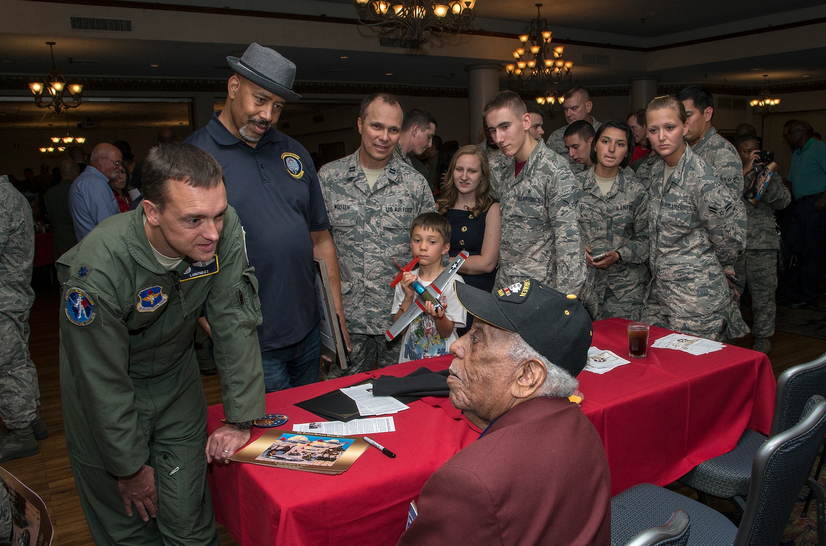 Members of the JBSA-Randolph community listen to Mr. Thomas M. Ellis, documented original Tuskegee Airmen, speak about his time serving with the Tuskegee Airmen during the Tuskegee Airmen Tribute, June 12, 2015, at Joint Base San Antonio-Randolph’s Parr Club.  Members of the JBSA-Randolph community celebrated the legacy of the first all-black unit by paying tribute to seven of the documented original Tuskegee Airmen members.  The Tuskegee Airmen distinguished themselves during World War II with more than 15,500 sorties and 1,500 missions in Europe and North Africa and earned numerous combat awards.  The event featured musical entertainment, comments by 12th Flying Training Wing leaders, an introduction of four Tuskegee Airmen present and a presentation of gifts to them. Members of the audience had an opportunity to mingle with the Tuskegee Airmen and listen to their stories. (U.S. Air Force photo by Johnny Saldivar/released)