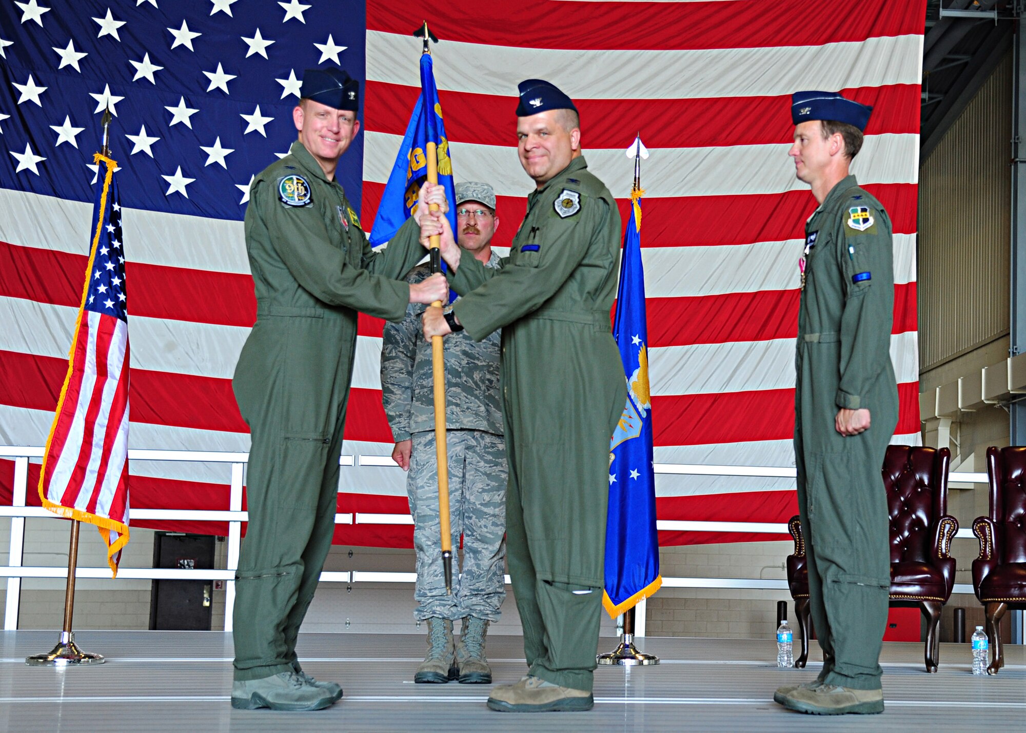 Col. Christopher Larson, 69th Reconnaissance Group commander, receives the guidon from Col. Douglas Lee, 9th Reconnaissance Wing commander, June 12, 2015 on Grand Forks Air Force Base, N.D. Larson took command from Col. Lawrence Spinetta, standing at right.(U.S. Air Force photo by Airman 1st Class Ryan Sparks/released)