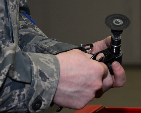 U.S. Air Force Airman 1st Class Donavan Jerles, 100th Maintenance Squadron Aircraft Structural apprentice from Gulf Shores, Ala., uses an angle grinder to work on a honeycomb core while preparing the material for fiberglass repair June 3, 2015, on RAF Mildenhall, England. The 90 degree angle grinder spins a sanding disk at a rapid rate to sand the excess core. The core is a similar structure to a bee’s honeycomb made from phenolic. (U.S. Air Force photo by Gina Randall/Released)