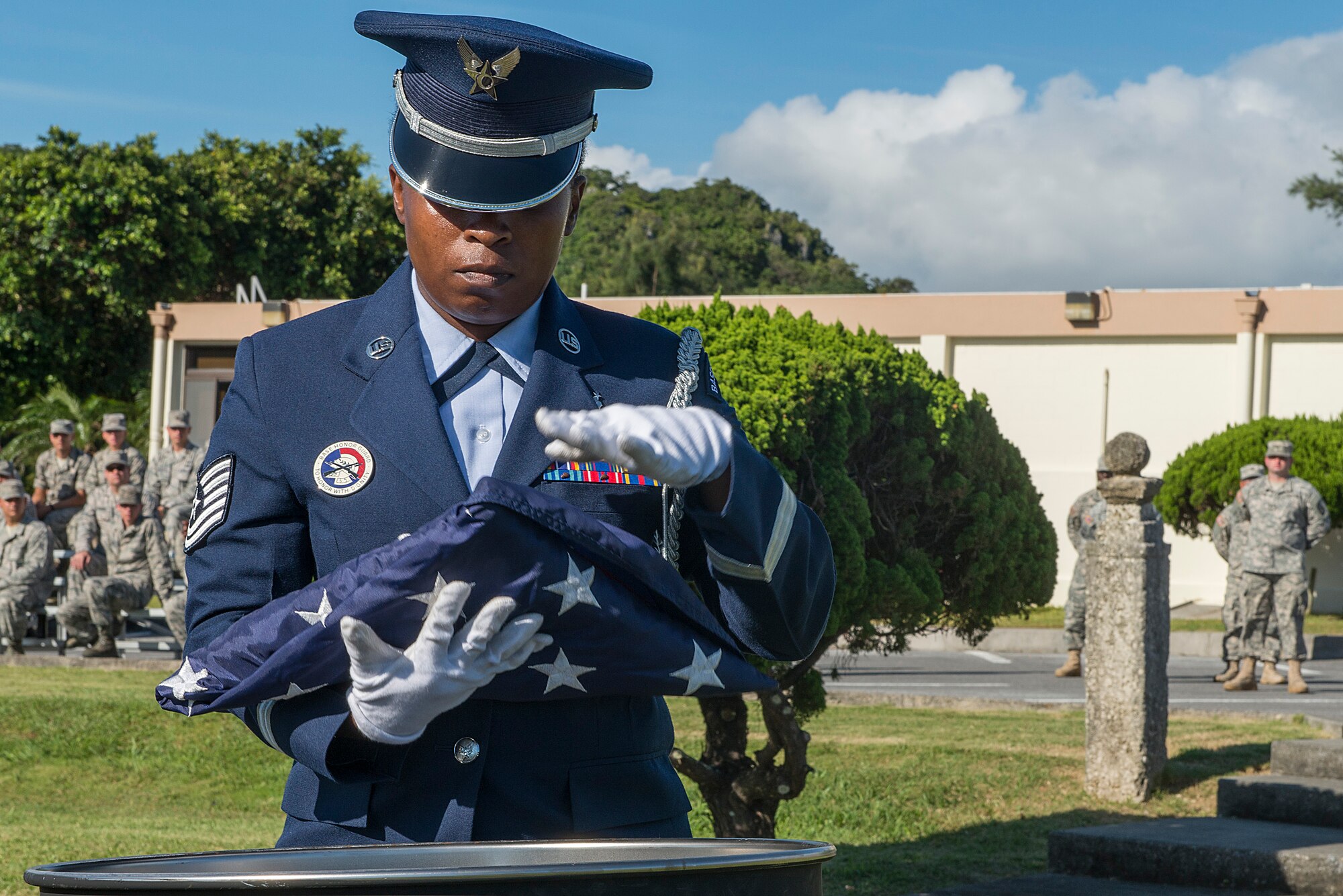 A Kadena Honor Guard member places the 18th Wing's folded decommissioned American flag into a burn barrel during the National Flag Day ceremony on Kadena Air Base, Japan, June 15, 2015. Displaying the flag and giving it a distinctive fold shows respect and expresses gratitude toward those who have fought and continue to fight for freedom at home and abroad. (U.S. Air Force photo by Senior Airman Stephen G. Eigel)