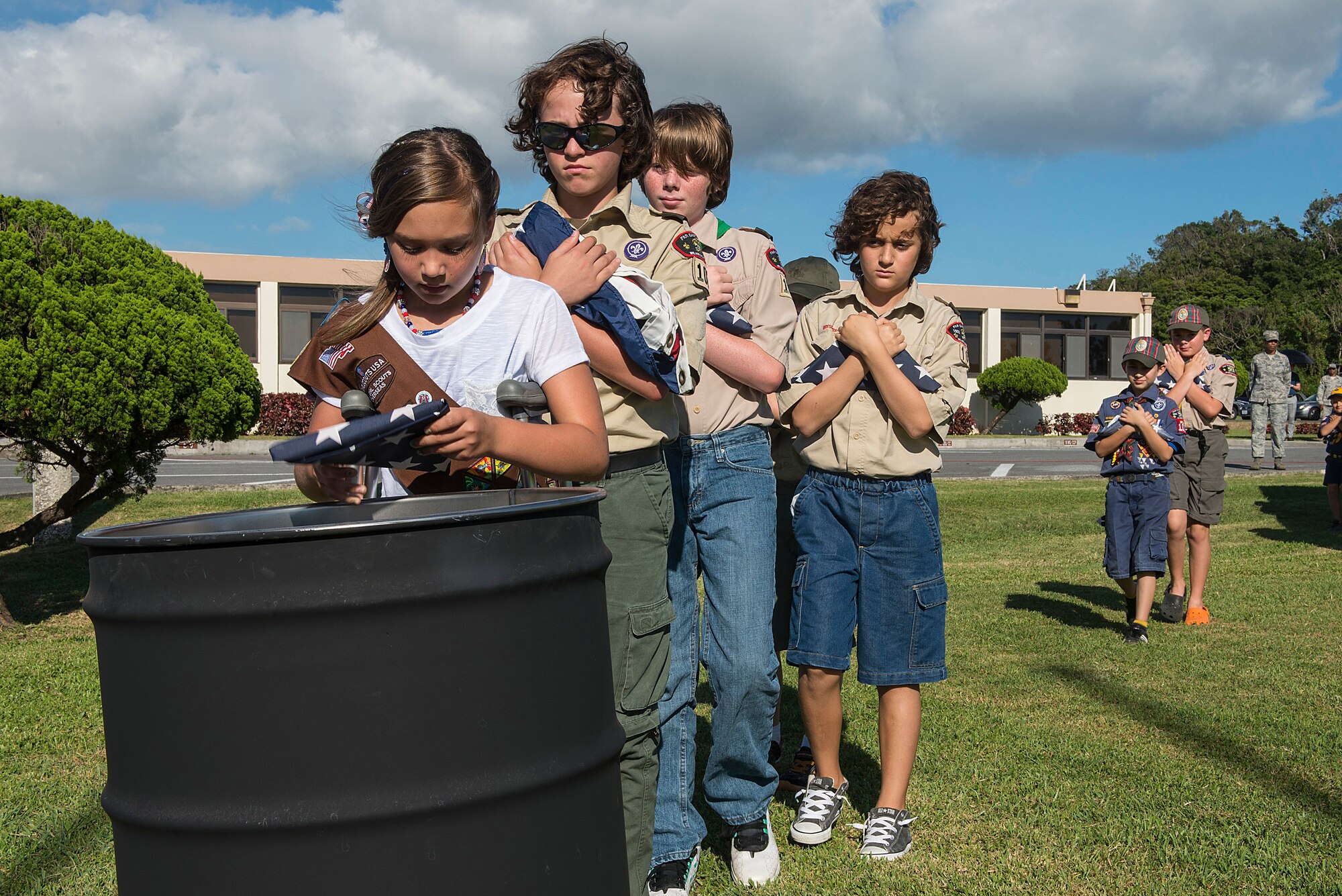 Kadena’s Girl Scouts and Cub Scouts Pack 102 place folded decommissioned American flags into a burn barrel during the Flag Day ceremony on Kadena Air Base, Japan, June 15, 2015. Displaying the flag and giving it a distinctive fold shows respect and expresses gratitude toward those who have fought and continue to fight for freedom at home and abroad. (U.S. Air Force photo by Senior Airman Stephen G. Eigel)