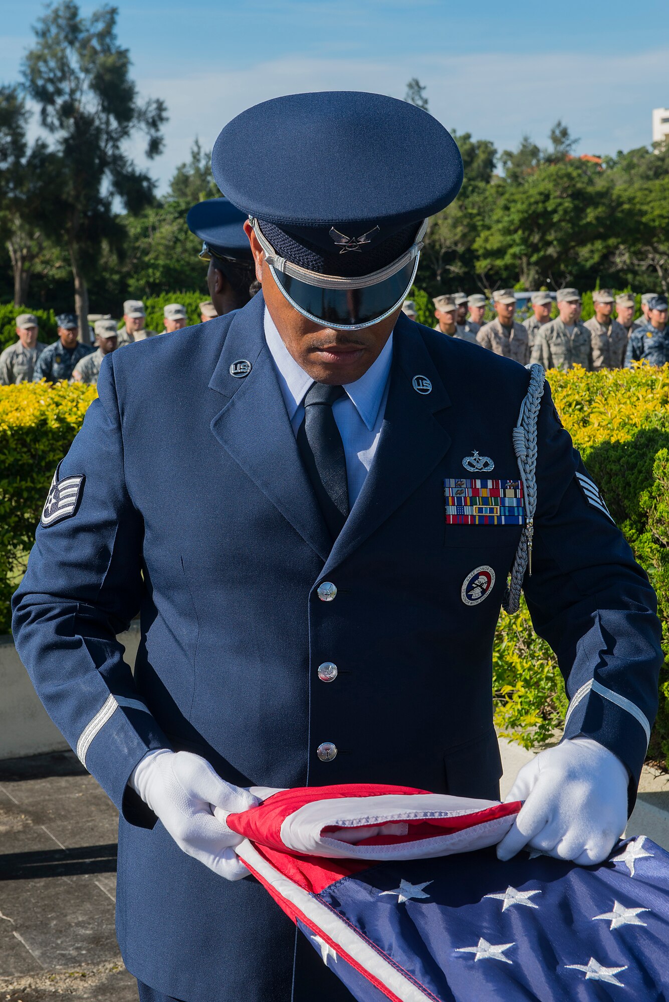 Kadena Honor Guard members fold the American flag during the National Flag Day ceremony on Kadena Air Base, Japan, June 15, 2015. The flag was decommissioned by the honor guard and represents all the flags collected, which were retired from service recently. Retired flags were taken to an alternate location after the ceremony and burned per regulation by 18th Civil Engineer Squadron fire protection personnel. (U.S. Air Force photo by Senior Airman Stephen G. Eigel)