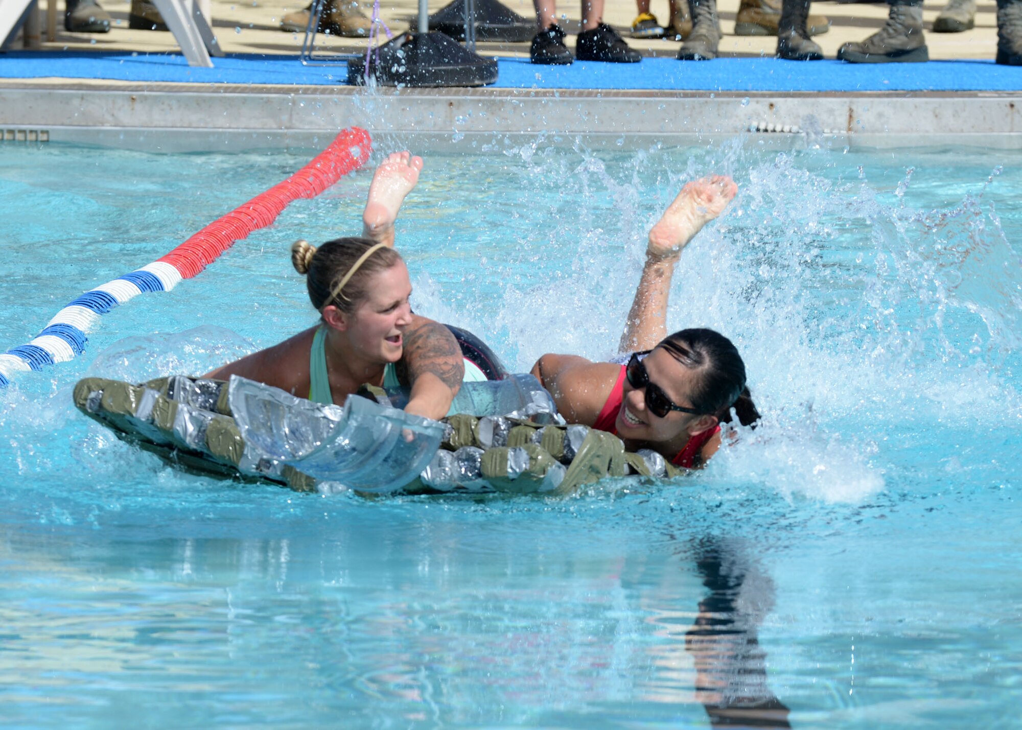 Senior Airman Michelle Ford and Airman 1st Class Taylor Ray, 36th Force Support Squadron, struggle to stay afloat during the Boat Blitz competition June 12, 2015, at Andersen Air Force Base, Guam. The race, hosted by the Coral Reef Fitness Center, featured two-member teams on a makeshift plastic bottle boat to race the length of the pool twice.  (U.S. Air Force photo by Airman 1st Class Joshua Smoot/Released)