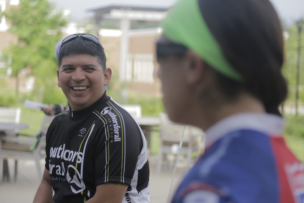 Army Chief Warrant Officer 3 Timothy Sifuentes talks with Army Staff Sgt. Monica Martinez at Fort Belvoir, Va., before cycling training for the 2015 Department Of Defense Warrior Games, June 14, 2015. Sifuentes and Martinez are two of more than 40 active duty and veteran athletes training at Fort Belvoir. Sifuentes will represent Team Army in the field, swimming and cycling competitions, and Martinez will compete in the cycling, field, sitting volleyball, swimming, track and archery competitions during the 2015 Department of Defense Warrior Games at Marine Corps Base, Quantico, Va., June 19-28, 2015. U.S. Army photo by Sgt. 1st Class Christophe Paul