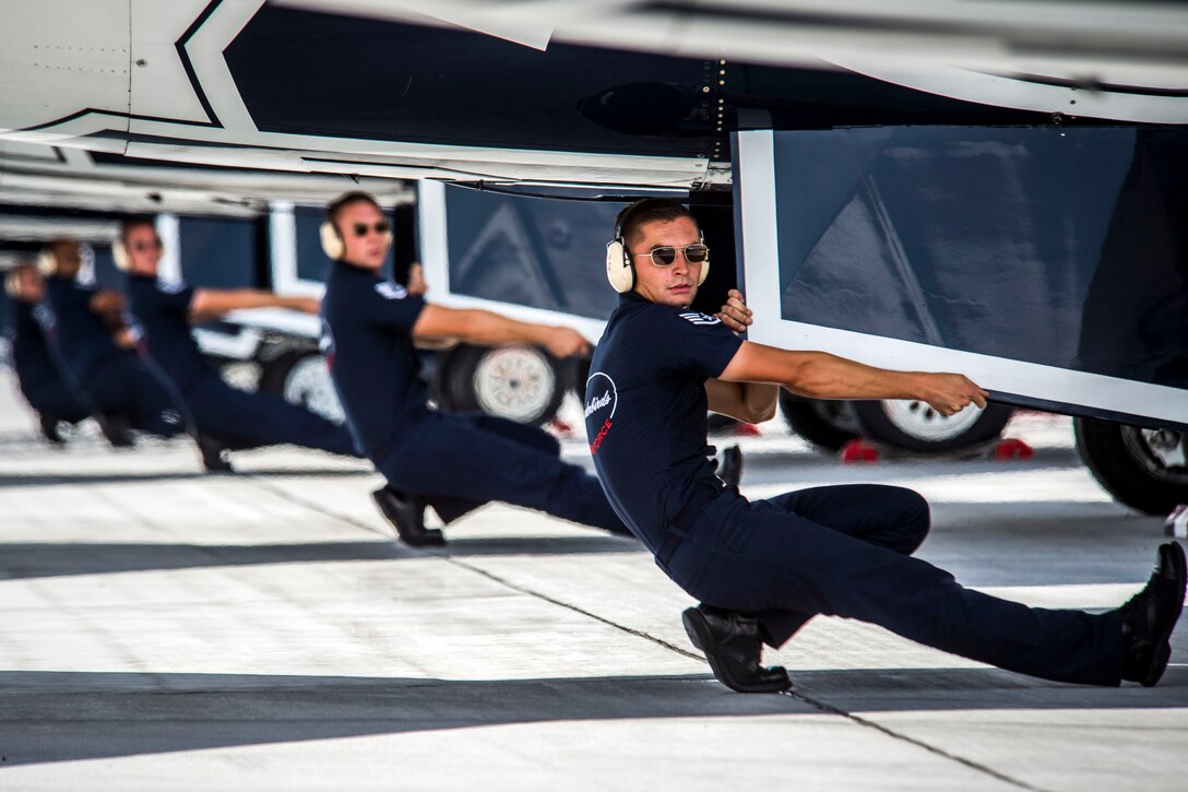 Thunderbird crew chiefs perform end of runway checks before the start of the demonstration for the Wings Over Whiteman practice airshow at Whiteman Air Force Base, Mo., June 12, 2015.