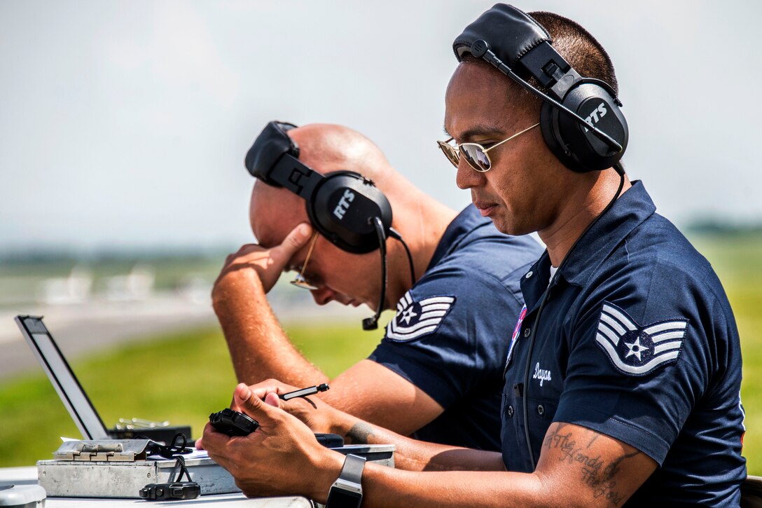 Air Force Staff Sgt. Jonathan Dayao, foreground, performs timing duties during the  Thunderbirds Wings Over Whiteman airshow at Whiteman Air Force Base, Mo., June 13, 2015. Dayao is a maintenance management production specialist.