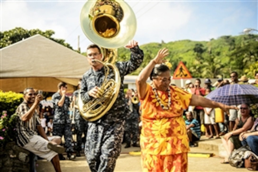 U.S. Navy Petty Officer 2nd Class Christian Ivy, left, performs with the Pacific Fleet Band as a Fijian woman dances during a Pacific Partnership 2015 event in Suvasuva, Fiji, June 13, 2015. Pacific Partnership is a multilateral humanitarian assistance and disaster relief preparedness mission. Ivy is assigned to the Military Sealift Command hospital ship USNS Mercy. 