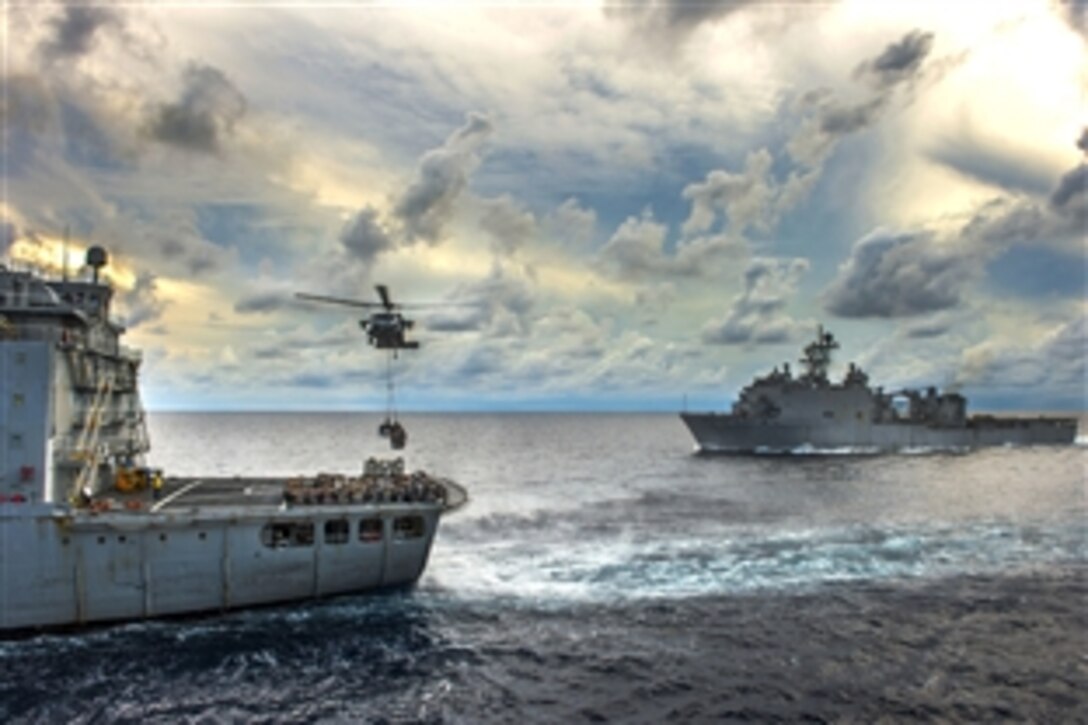 An MH-60S Seahawk helicopter lifts pallets of supplies from the flight deck of the Military Sealift Command fleet replenishment oiler USNS Walter S. Diehl  during a vertical replenishment  with the  amphibious assault ship USS Essex in the South China Sea, June 14, 2015. 
