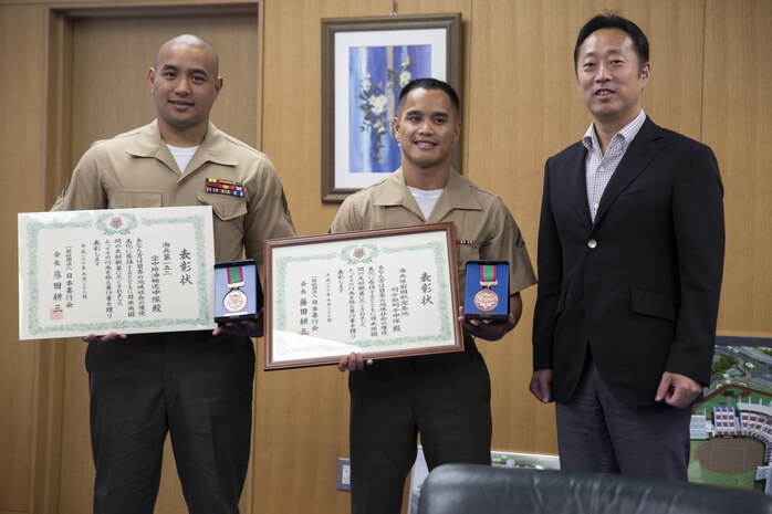 Sgt. Carlos Notarianni, left, the representative for VMGR-152, Lance Cpl. Adam Gordy, middle, the representative for H&HS, and Yoshihiko Fukuda, right, mayor of Iwakuni City, pose for a picture after their meeting at city hall June 3, 2015. The representatives went to city hall to report to the mayor after receiving awards from the Japan Good Deeds Association during their 65th Spring Commendation Ceremony in May. H&HS and VMGR-152 received the awards for assisting the local community whose homes were affected by a mudslide in August 2014.