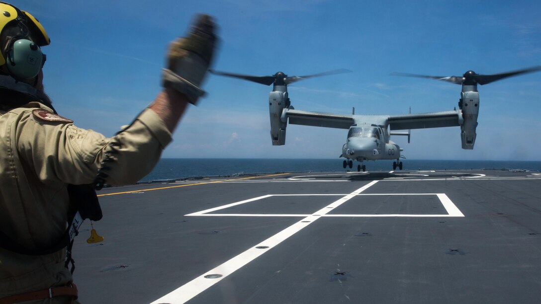 Sgt. Maj. Jan Bult, a member of the Royal Netherlands Navy, directs the landing of an MV-22 Osprey with Marine Medium Tiltrotor Squadron 261 onto the Karel Doorman, a Dutch warship, during an interoperability test near Marine Corps Air Station New River, N.C., June 12, 2015. The units worked jointly to perform the first MV-22 Osprey carrier landing aboard a Dutch warship and strengthened the existing partnership between the two countries. 