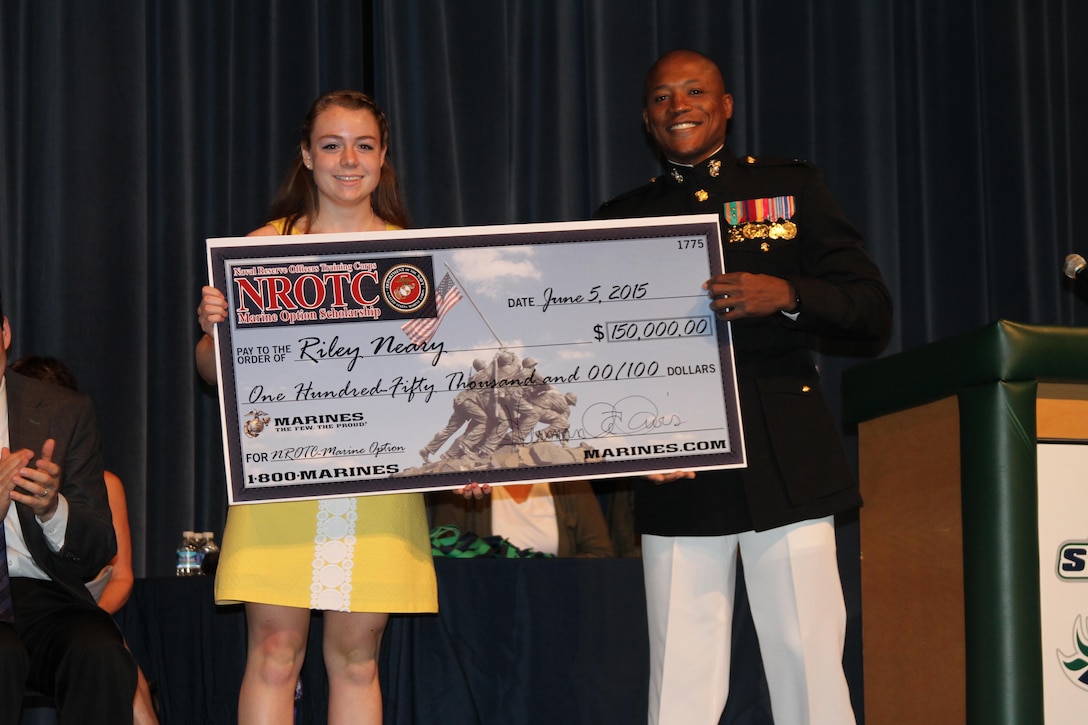 Riley Neary, left, an Alexandria, Virginia native and South County High School senior, receives a $150,000 Naval Reserve Officers Training Corps Marine Option Scholarship during a high school awards ceremony at South County High School, June 5, 2015. U.S. Marine Corps Capt. Herman Davis, executive officer of Marine Corps Recruiting Station Frederick presented Neary with the scholarship, which will cover the cost of tuition, books, and a small living stipend. (U.S. Marine Corps photo by Sgt. Anthony Kirby/Released)