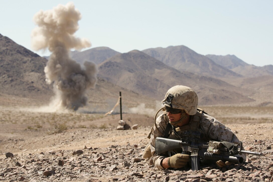 Colton Derick, a rifleman with Company B, 1st Battalion, 23rd Marine Regiment, 4th Marine Division, Marine Forces Reserve, lays down for cover during a simulated enemy explosion during the live fire company attacks during the Integrated Training Exercise 4-15 aboard Marine Corps Air Ground Combat Center Twentynine Palms, Calif., June 13, 2015. The unique terrain and weather conditions at the range combined with the exercise simulation provide the most realistic experience of what they would go through during a deployment to the Middle East. (U.S Marine Corps photo by Cpl. Ian Ferro)