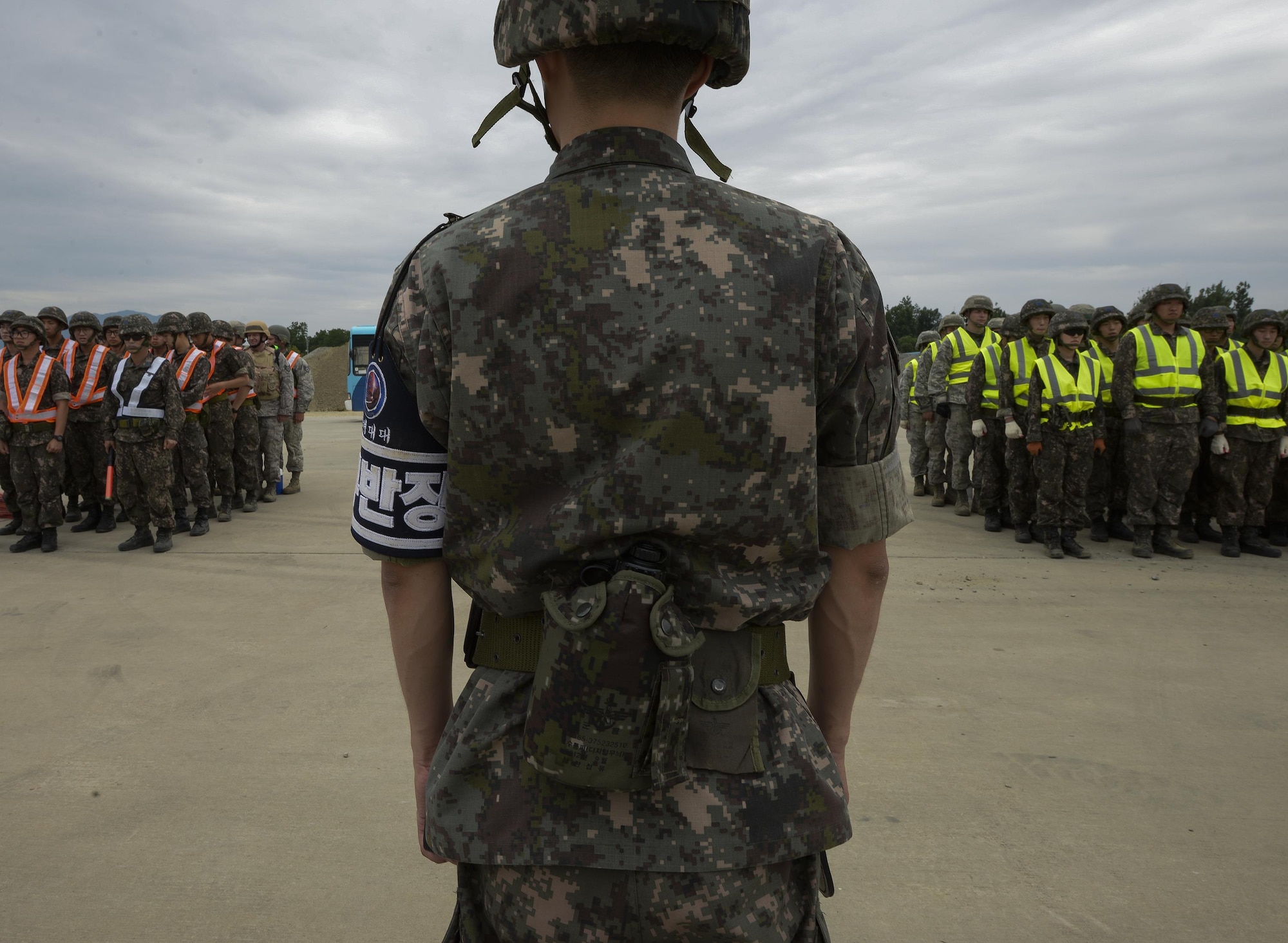 Civil engineer service members from the U.S. and South Korea assemble in formation before being dispatched to repair a runway for exercise Pacific Unity, June 11, 2015, at Jungwon Air Base, South Korea. The goal of Pacific Unity was to develop U.S. Air Force and South Korea engineer interoperability for rapid responses to contingency and disaster response events. (U.S. Air Force photo/Staff Sgt. Jake Barreiro)