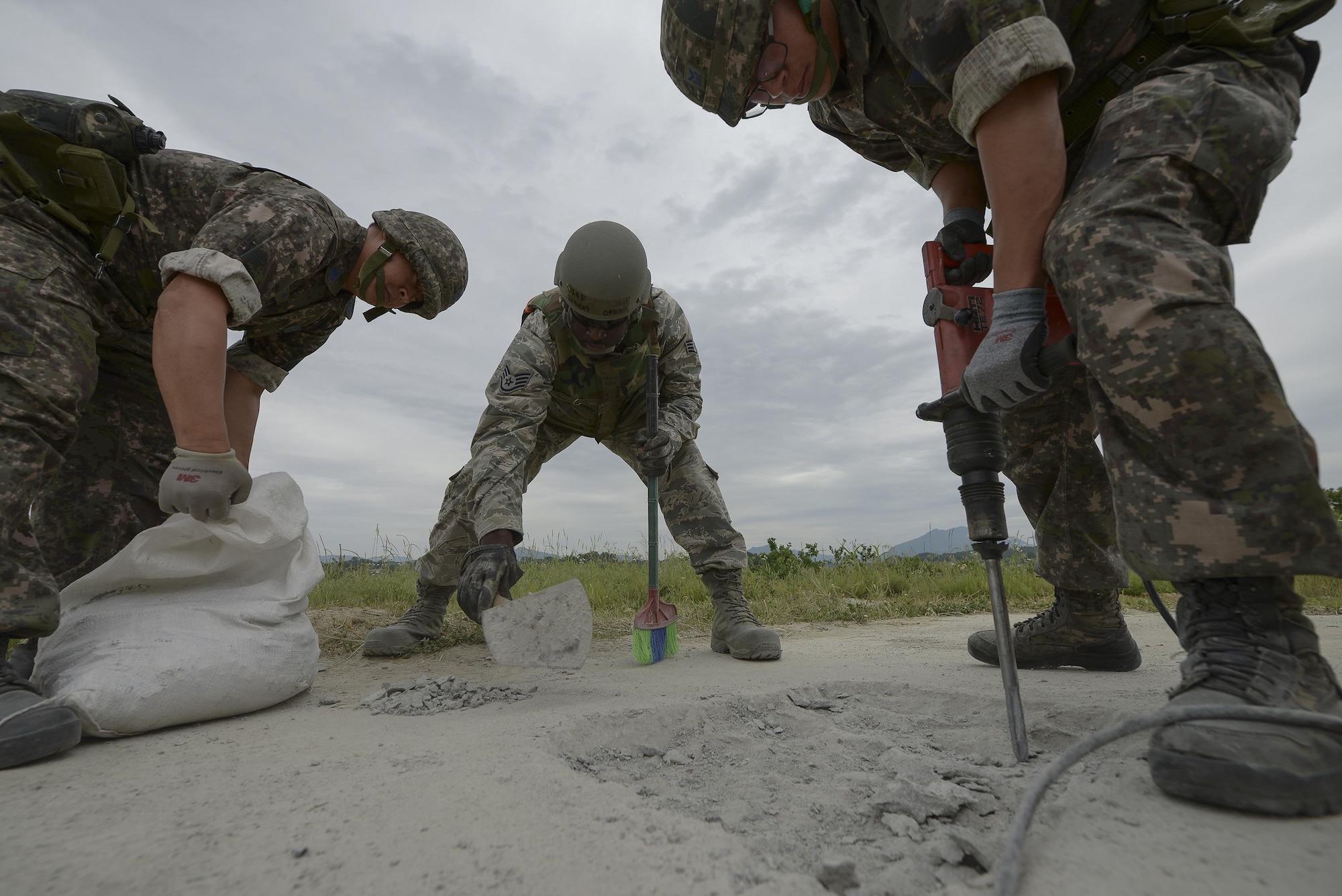 Airmen from the U.S. and South Korea work together to repair a damaged runway during exercise Pacific Unity, June 11, 2015, at Jungwon Air Base, South Korea. The exercise was designed to give U.S. and South Korean airmen the chance to further develop their international relationship by networking and exchanging information, while working together in a simulated contingency. (U.S. Air Force photo/Staff Sgt. Jake Barreiro)