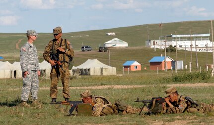 Alaska Army National Guard Master Sgt. Eric Schlemme and Mongolian Armed
Forces Senior Sergeant Battulga Baatar discuss tactics and techniques used
by the Mongolian Expeditionary Force executing a traffic control point
training lane at Five Hills Training Area in Mongolia during Khaan Quest
2009. Schlemme also deployed with the MEF to Afghanistan as an embedded U.S.
liaison.