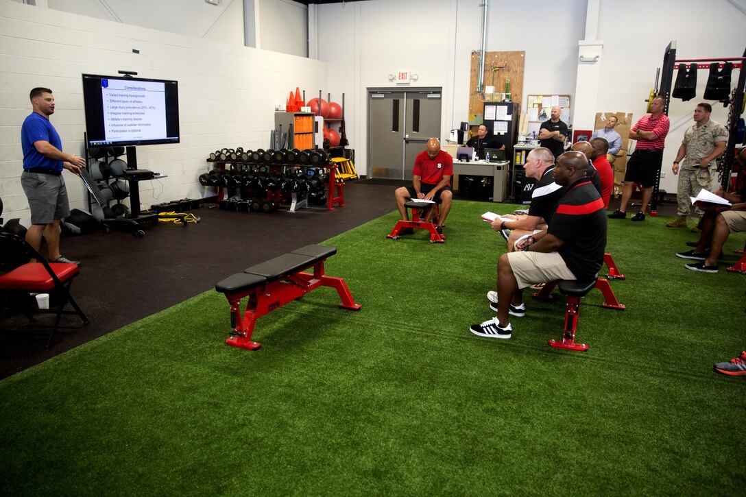 The N.C. State University football coaching staff visits members of Marine Corps Forces Special Operations Command at the Performance and Resiliency annex at Stone Bay, aboard Marine Corps Base Camp Lejeune, N.C., June 10, 2015. MARSOC personnel briefed the coaching staff about U.S. Special Operations Command’s Military Preservation Of The Force and Family program. The MPOTFF program is designed to foster a commander-driven, organizational culture of physical, mental, spiritual, and family excellence through responsive resourcing to enhance mission success in career, family and all other life areas at MARSOC and beyond.