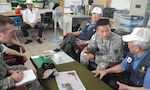 In this photo, Korean Augmentee to the U.S. Army Pfc. Ho Yeon Lee, community relations specialist assigned to the 35th Air Defense Artillery Brigade, speaks with O Jae Kwon at the Ministry of Patriots and Veterans Affairs -- Osan branch June 3, 2015 to discuss Kwon's military service during the Korean War. Kwon served in the Republic of Korea Army for four years. 
