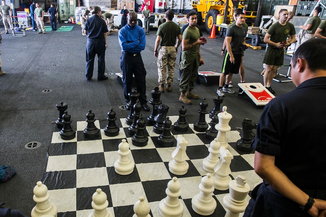 U.S. Marines and Sailors aboard the USS Essex (LHD 2) play games in the hangar bay at sea in the Strait of Malacca, June 15, 2015. The Marines with the 15th Marine Expeditionary Unit and Sailors with the Essex Amphibious Ready Group enjoyed a “Steel Beach,” which consisted of grilling, music, and games. (U.S. Marine Corps photo by Cpl. Anna Albrecht/Released)