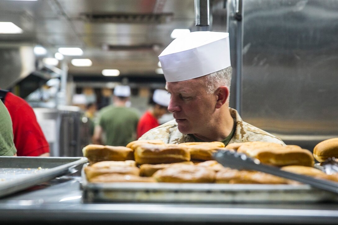 U.S. Marine Lt. Col. James Fallon helps out in the galley of the USS Essex (LHD 2) at sea in the Strait of Malacca, June 15, 2015. Fallon is the executive officer of 15th Marine Expeditionary Unit. The Marines and Sailors aboard the USS Essex enjoyed a “Steel Beach,” which consisted of grilling and playing games in the hangar bay. (U.S. Marine Corps photo by Cpl. Anna Albrecht/Released)